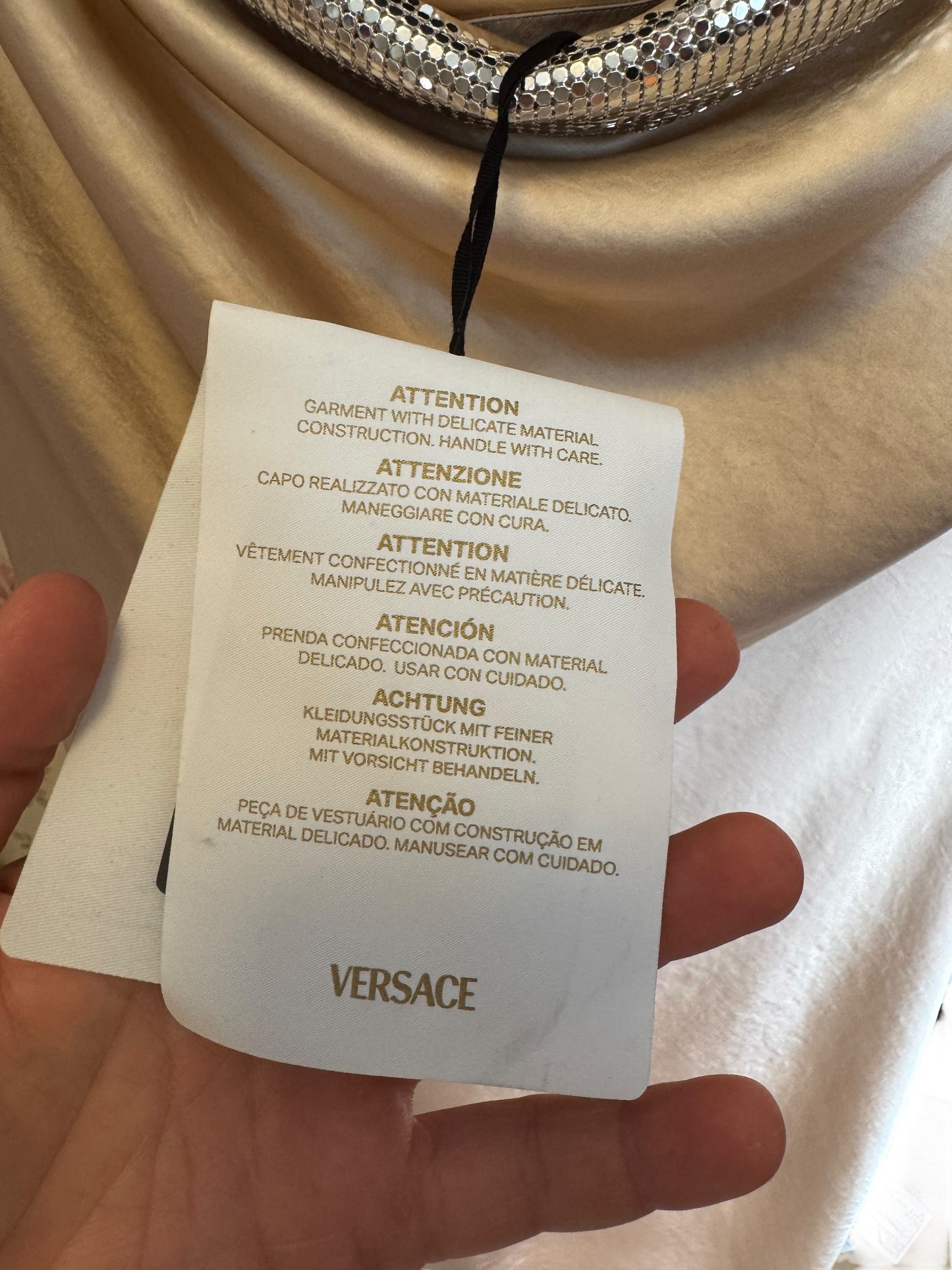 Vestito Versace in raso champagne con scollo drappeggiato e dettagli metallici