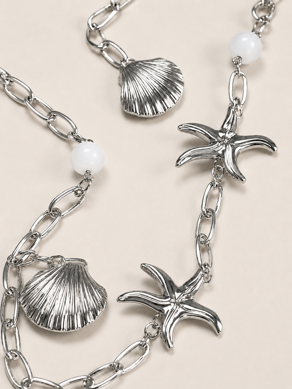 Collana lunga argentata con conchiglie e stelle marine