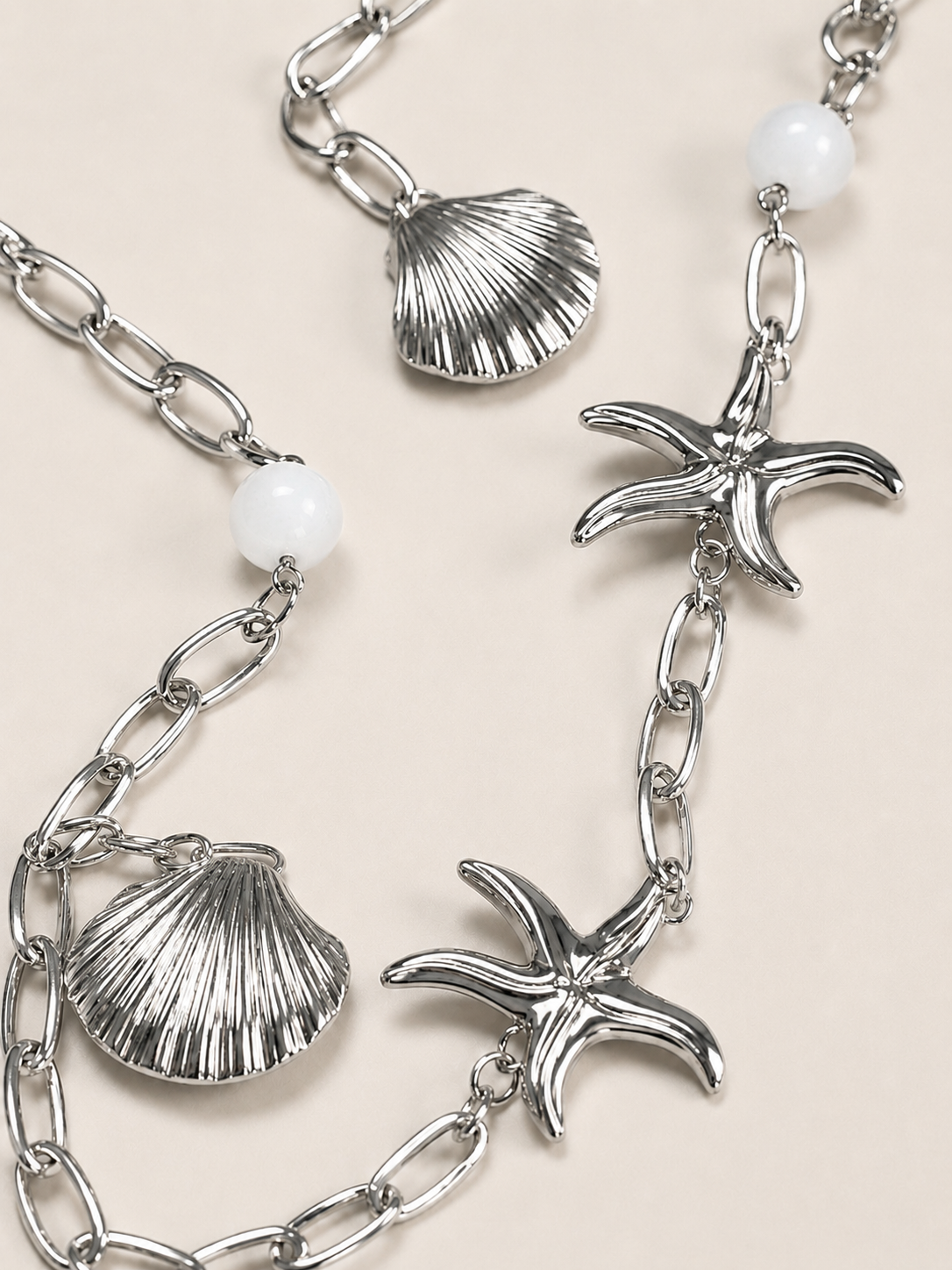 Collana lunga argentata con conchiglie e stelle marine