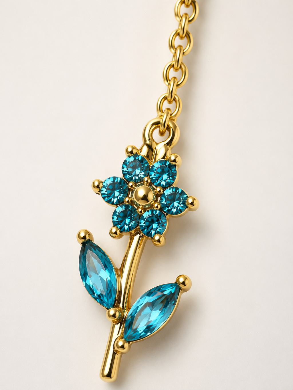 Collana dorata con fiore e cristalli azzurri