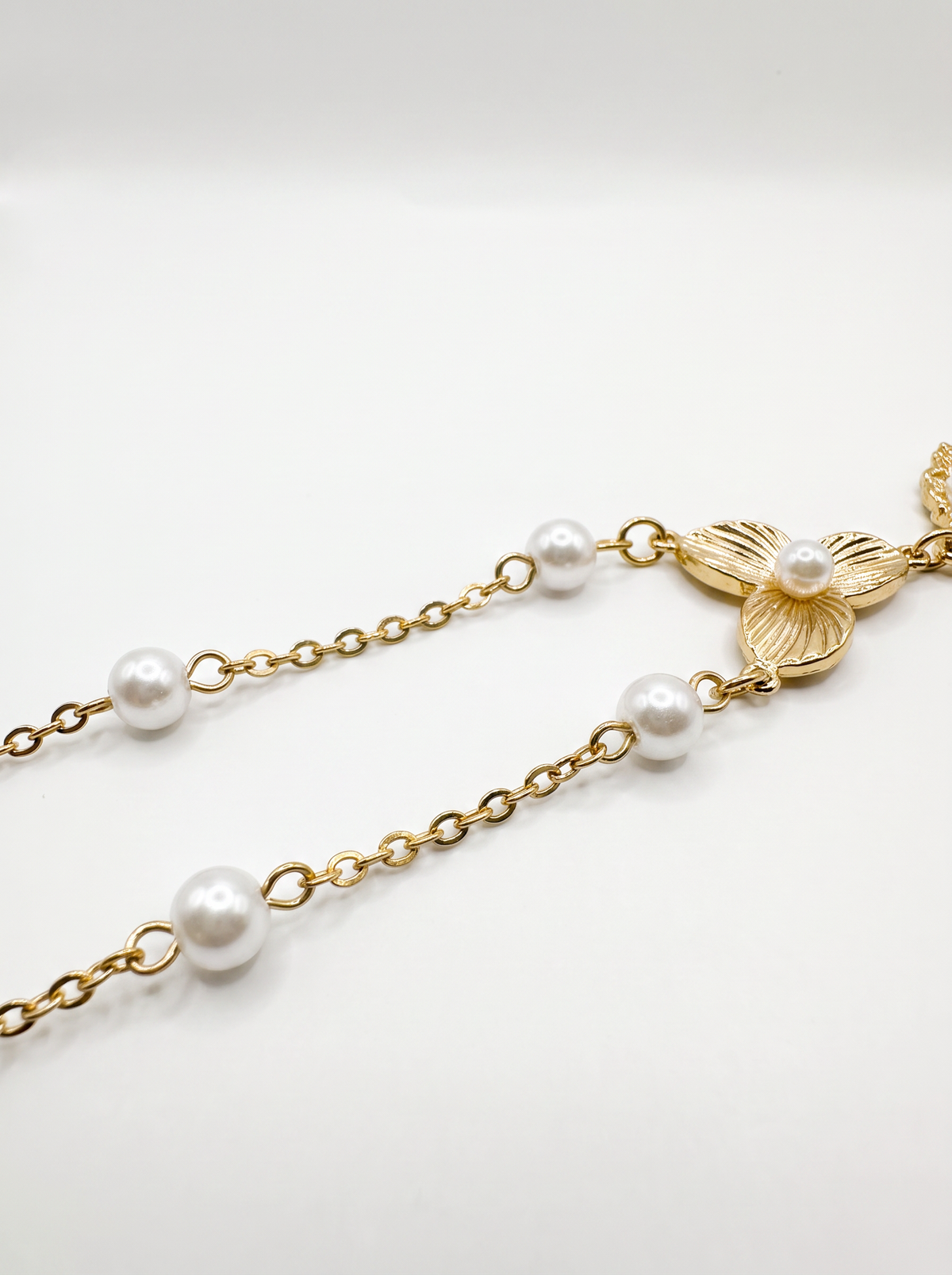 Collana lunga dorata con perle e cameo floreale
