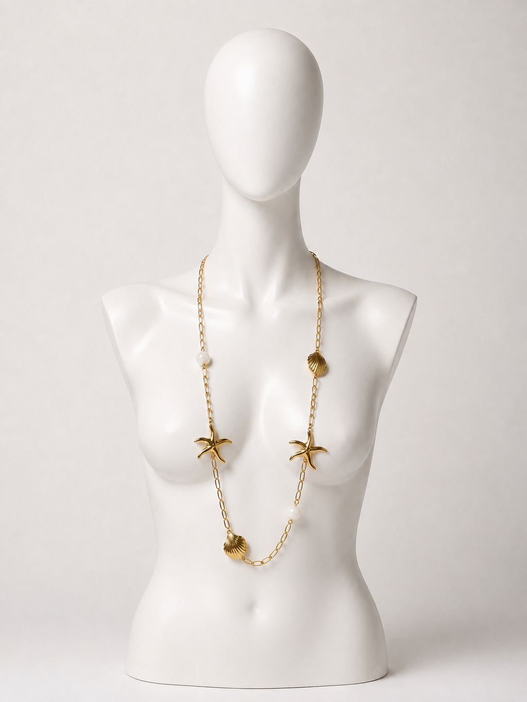 Collana lunga dorata con conchiglie, stelle marine e perle bianche