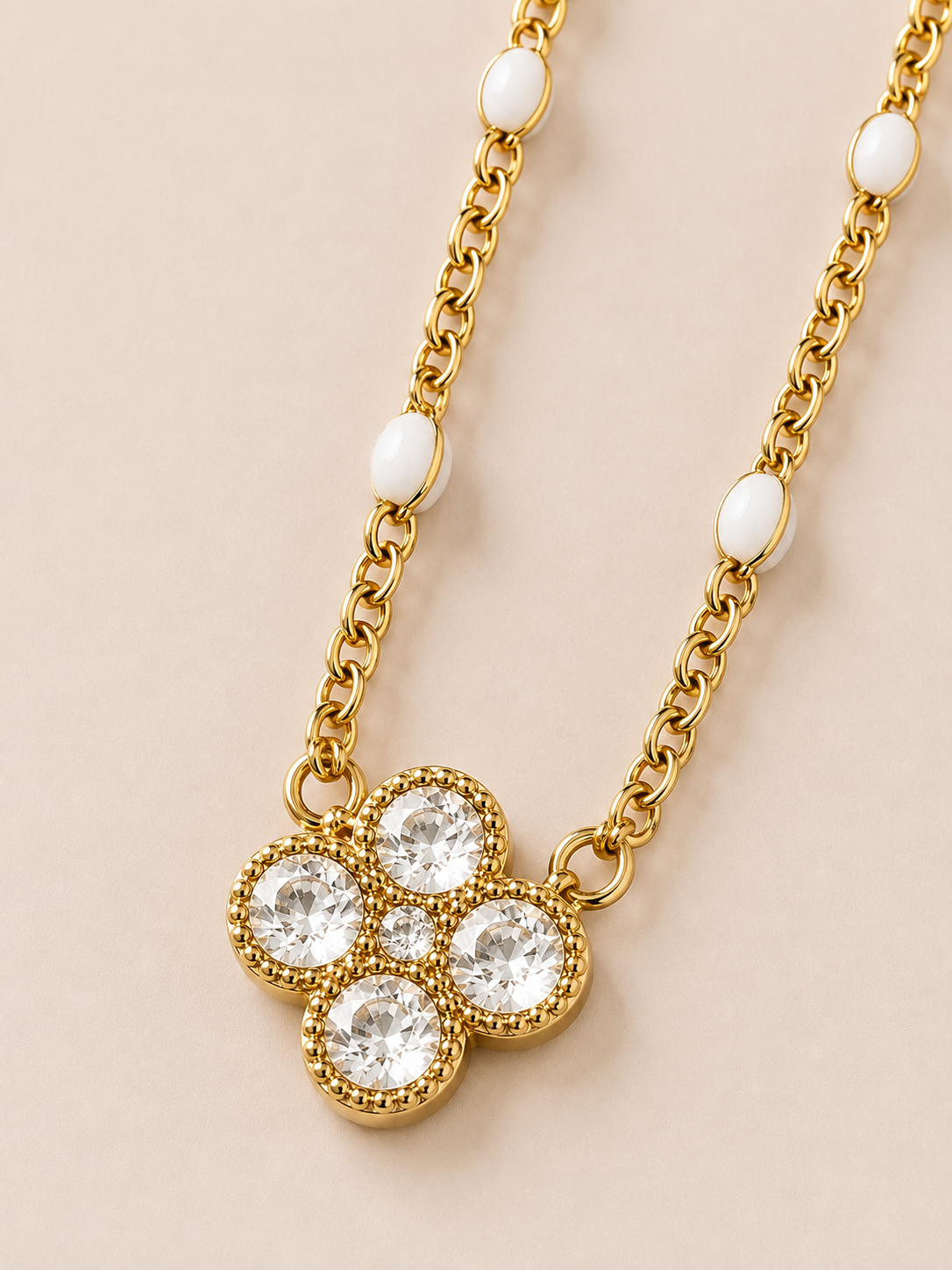 Collana dorata con fiore, cristalli e dettagli bianchi
