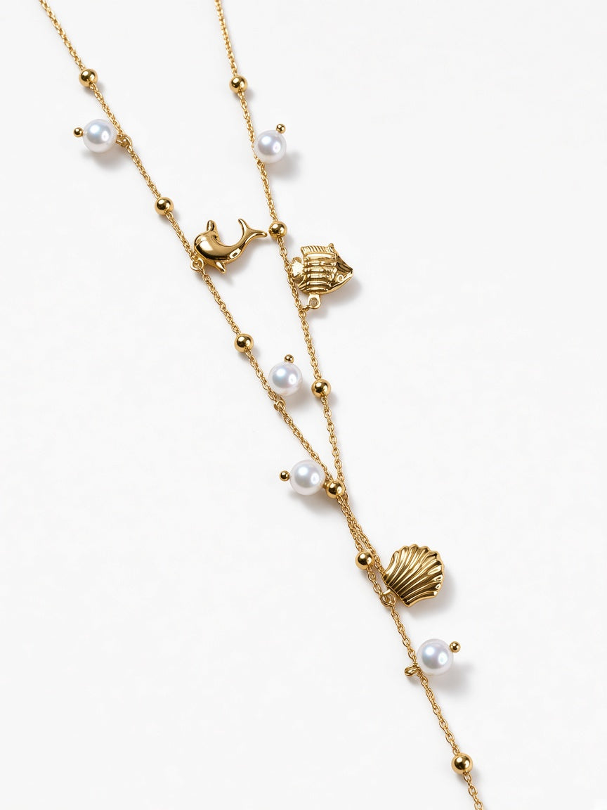 Collana dorata con charms marini e perle