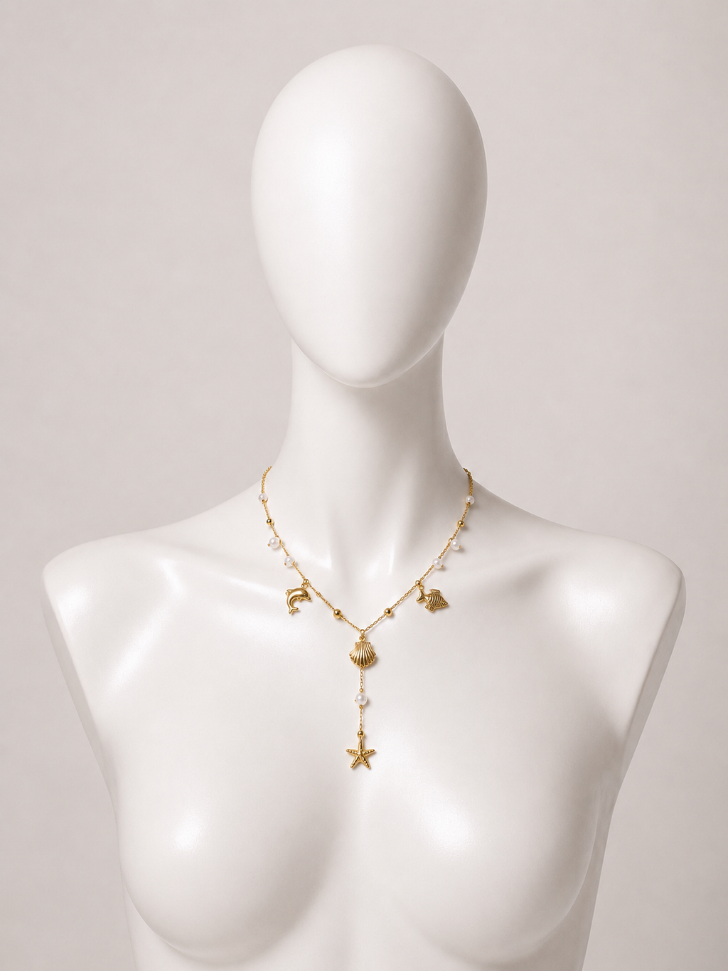 Collana dorata con charms marini e perle