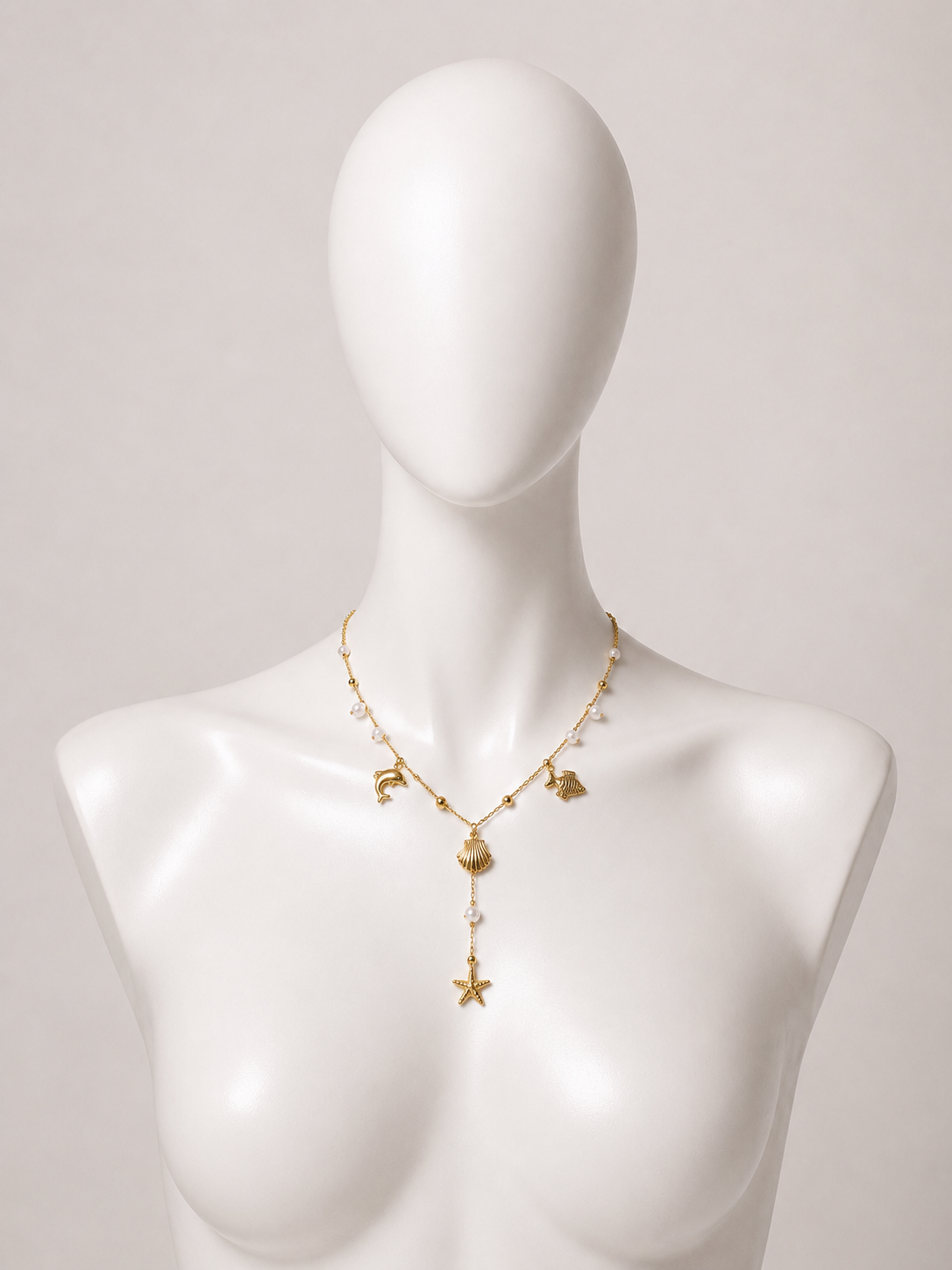 Collana dorata con charms marini e perle